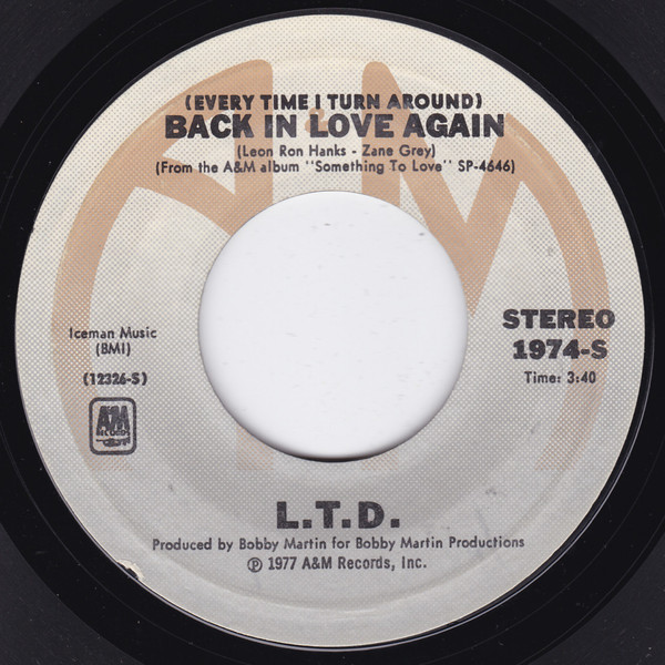 L.T.D. – (Every Time I Turn Around) Back In Love Again/Material Things (7" Vinyl)